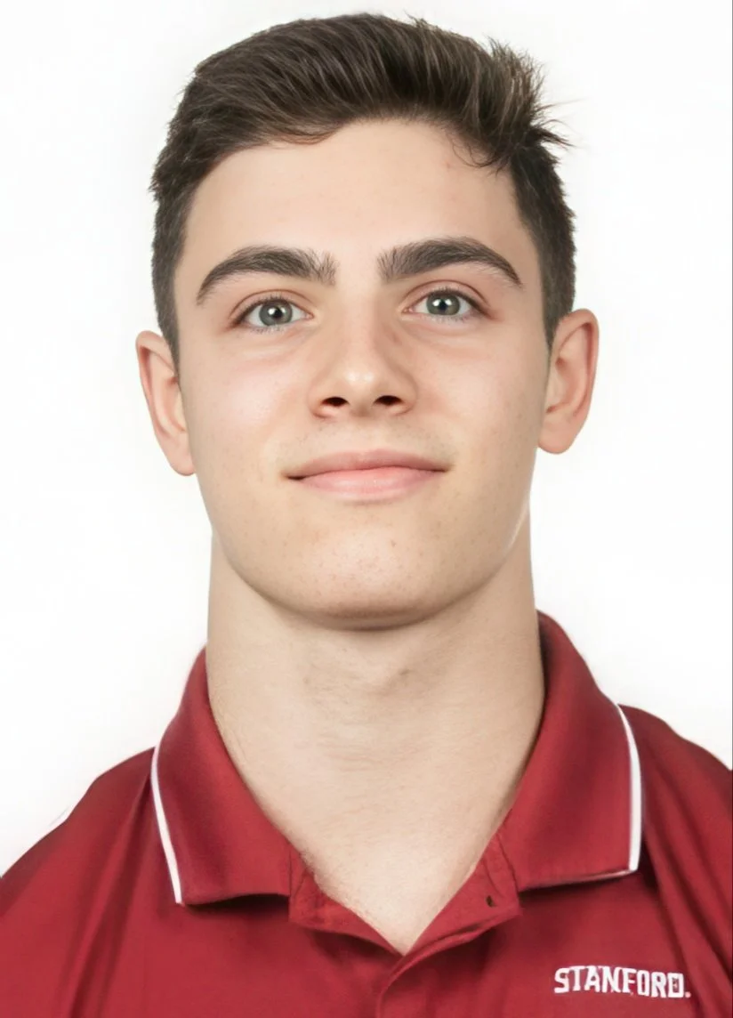A young man with short brown hair and fair skin, wearing a maroon shirt with white piping and the word 'STANFORD' embroidered on it, standing against a plain white background.