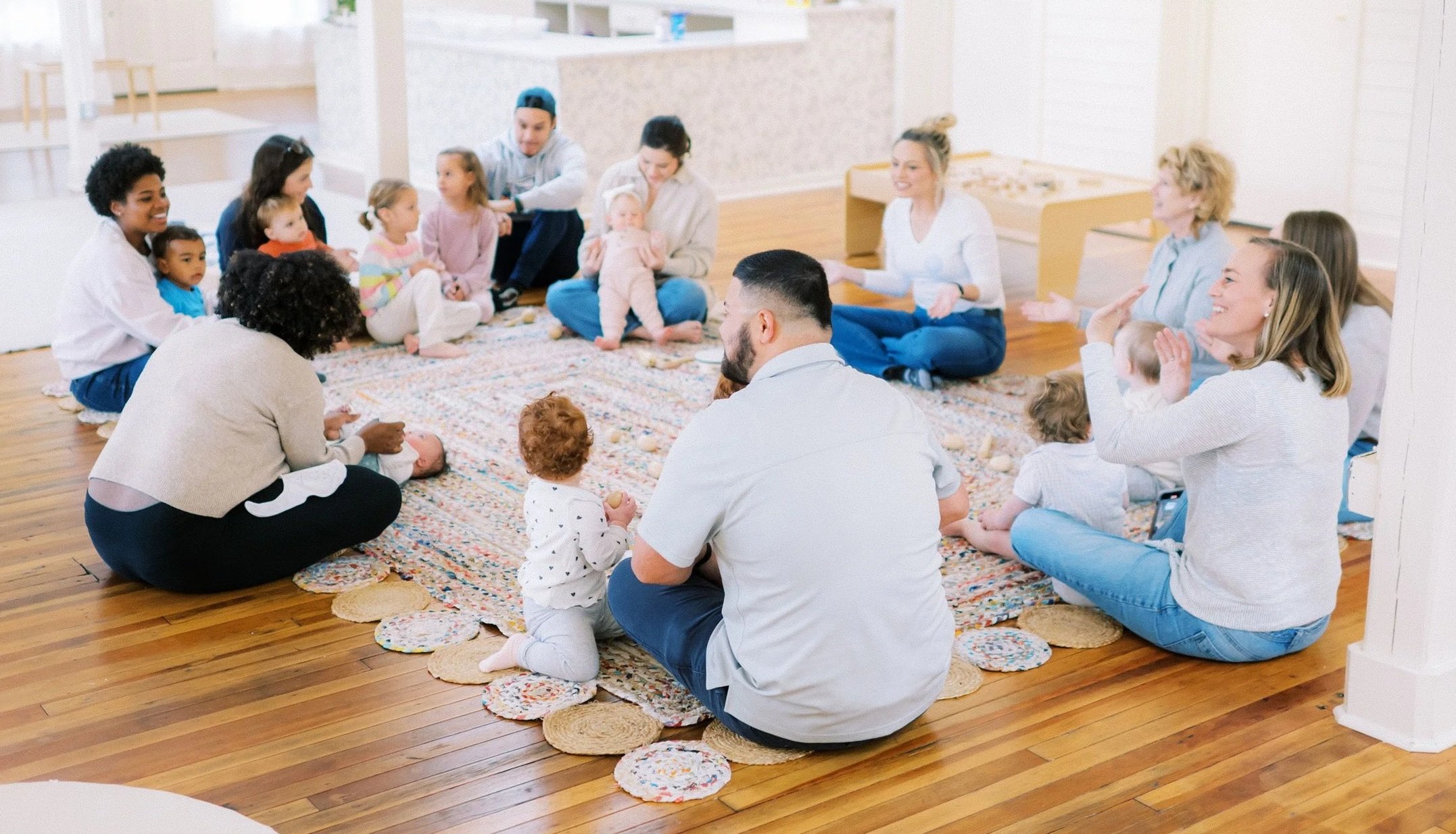 Parents participating in a Mom League Newborn Series class in Winston-Salem, seated in a circle with their babies.