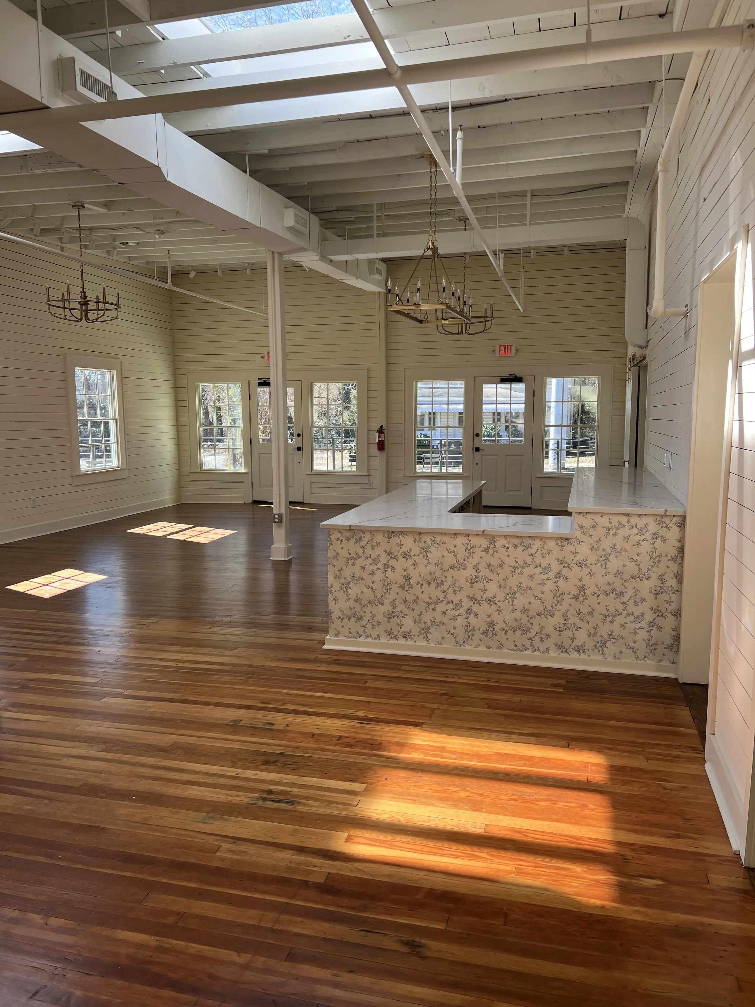 Interior of The Reverie with white paneled walls and chandeliers in Winston-Salem, NC.