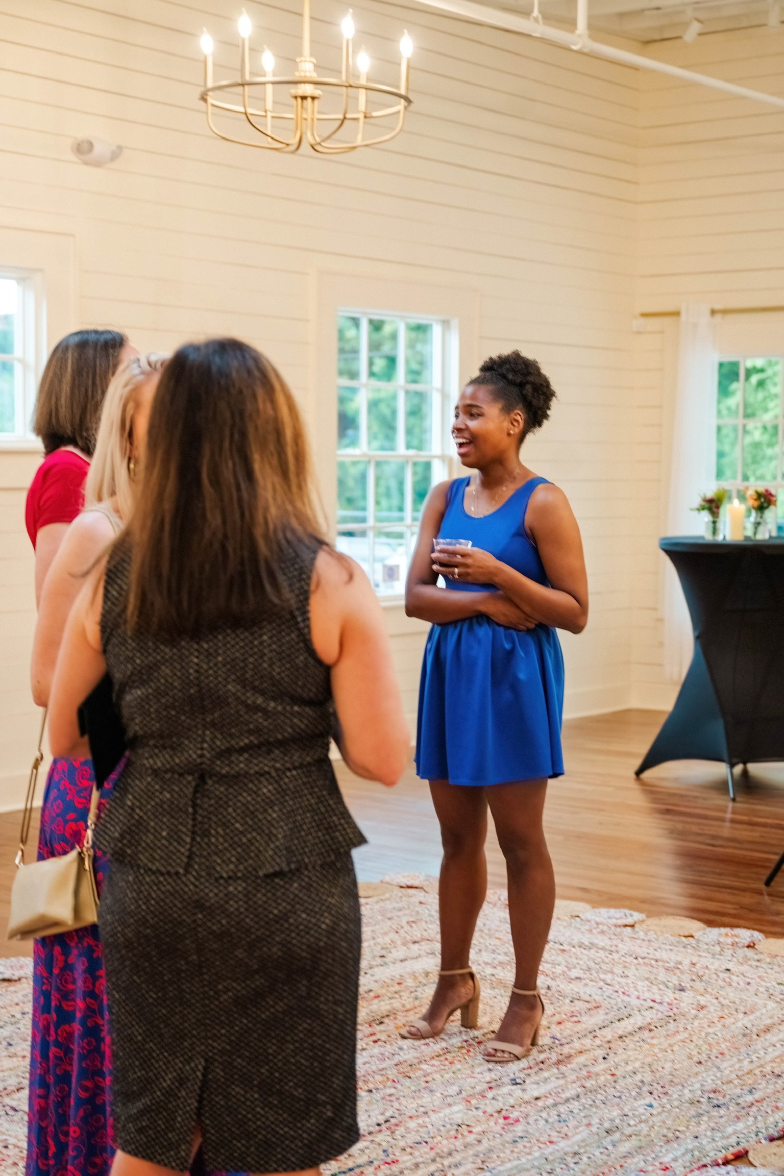 Moms gathering in a bright Winston-Salem event space during a Mom League social event.