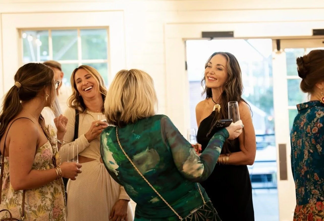 Moms chatting and connecting during a Mom League social event in Winston-Salem.
