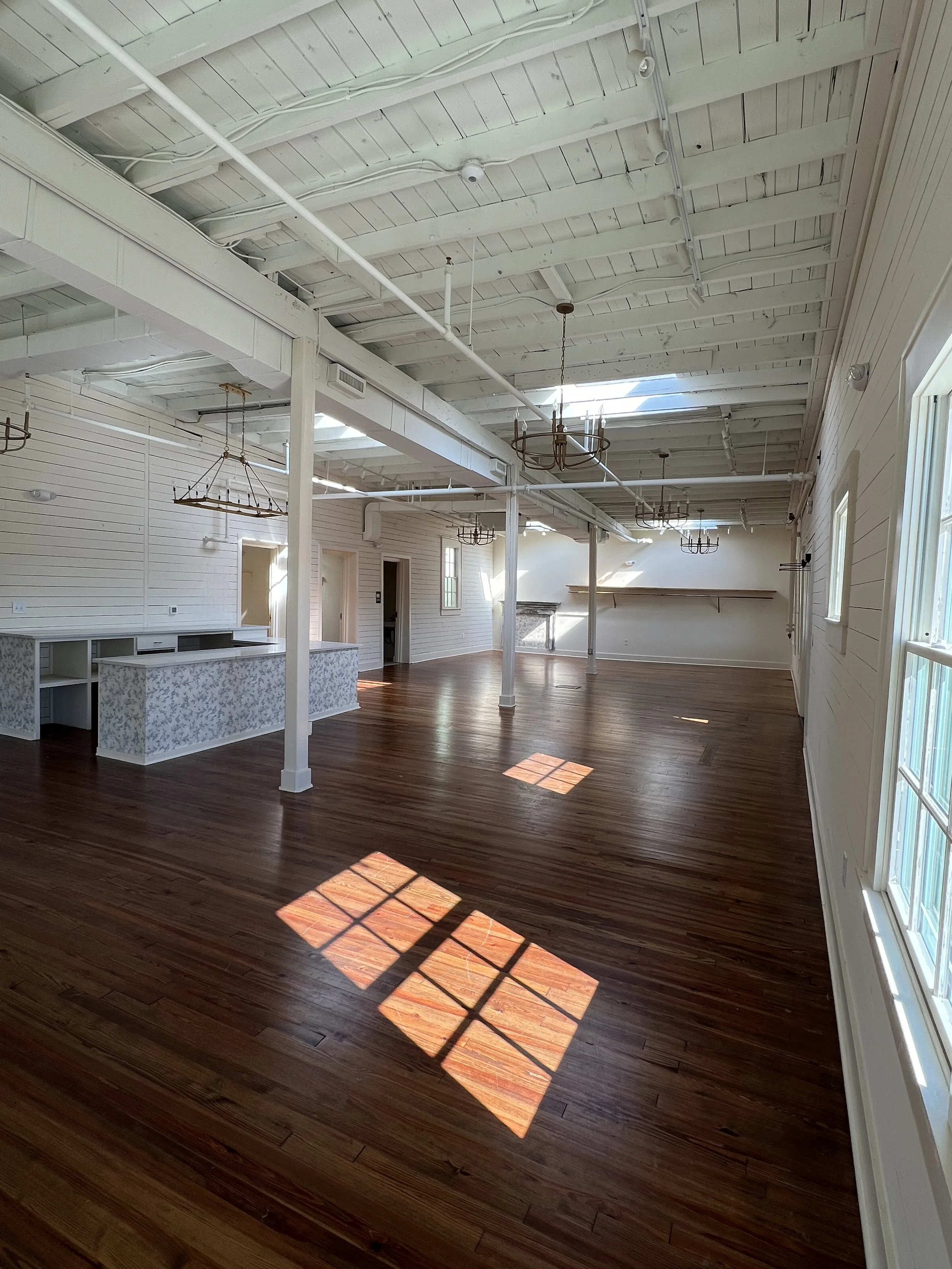 Empty event space at The Reverie in Winston-Salem, featuring white shiplap walls and natural light.