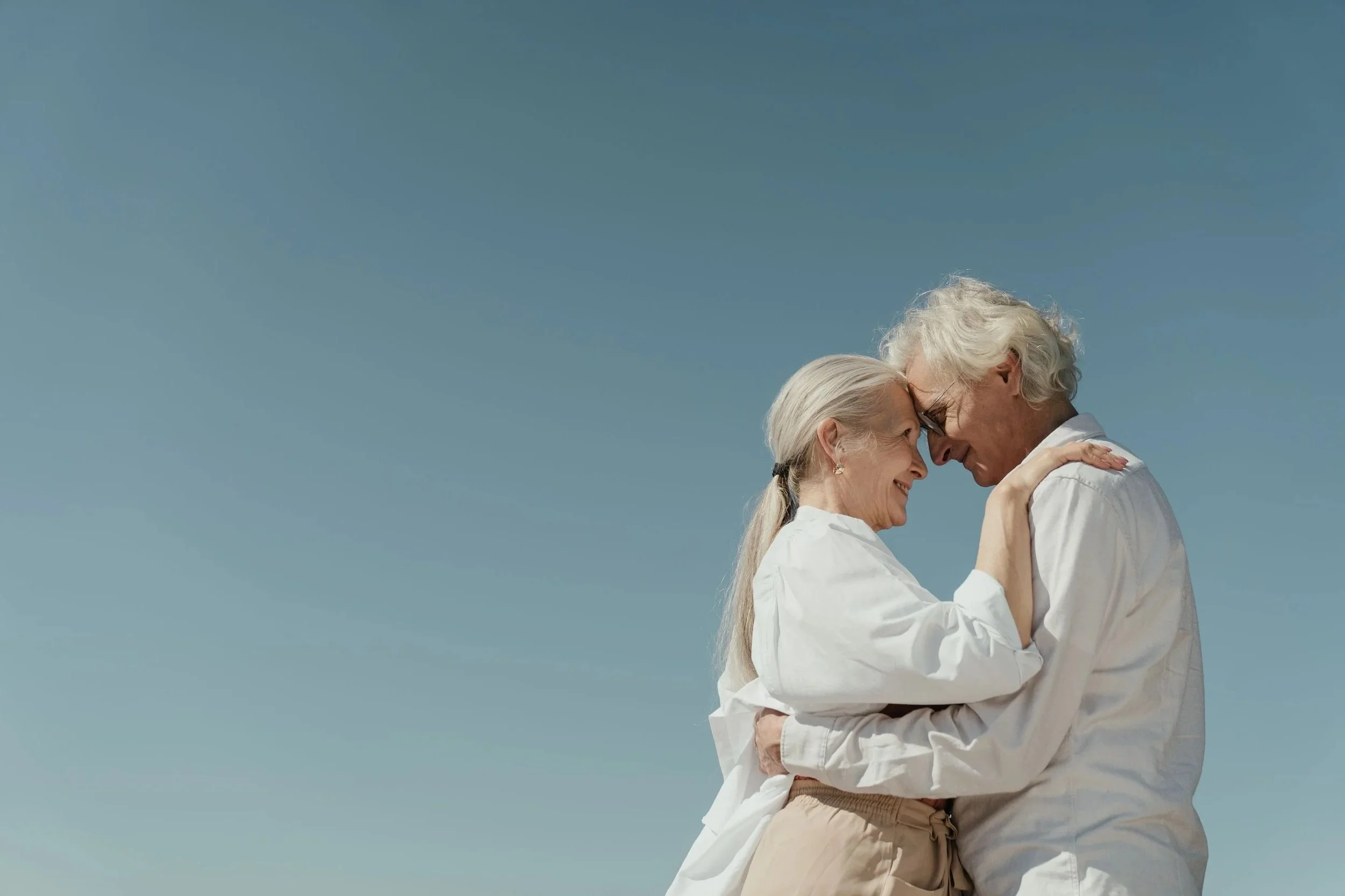 Senior couple looking at each other and embracing.
