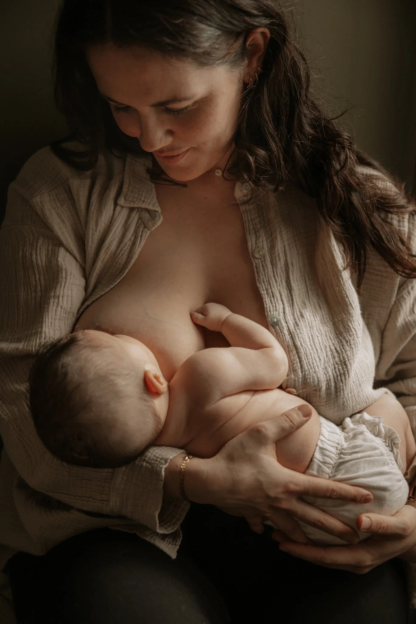 Une femme allaitant un bébé dans un cadre chaleureux et intime.