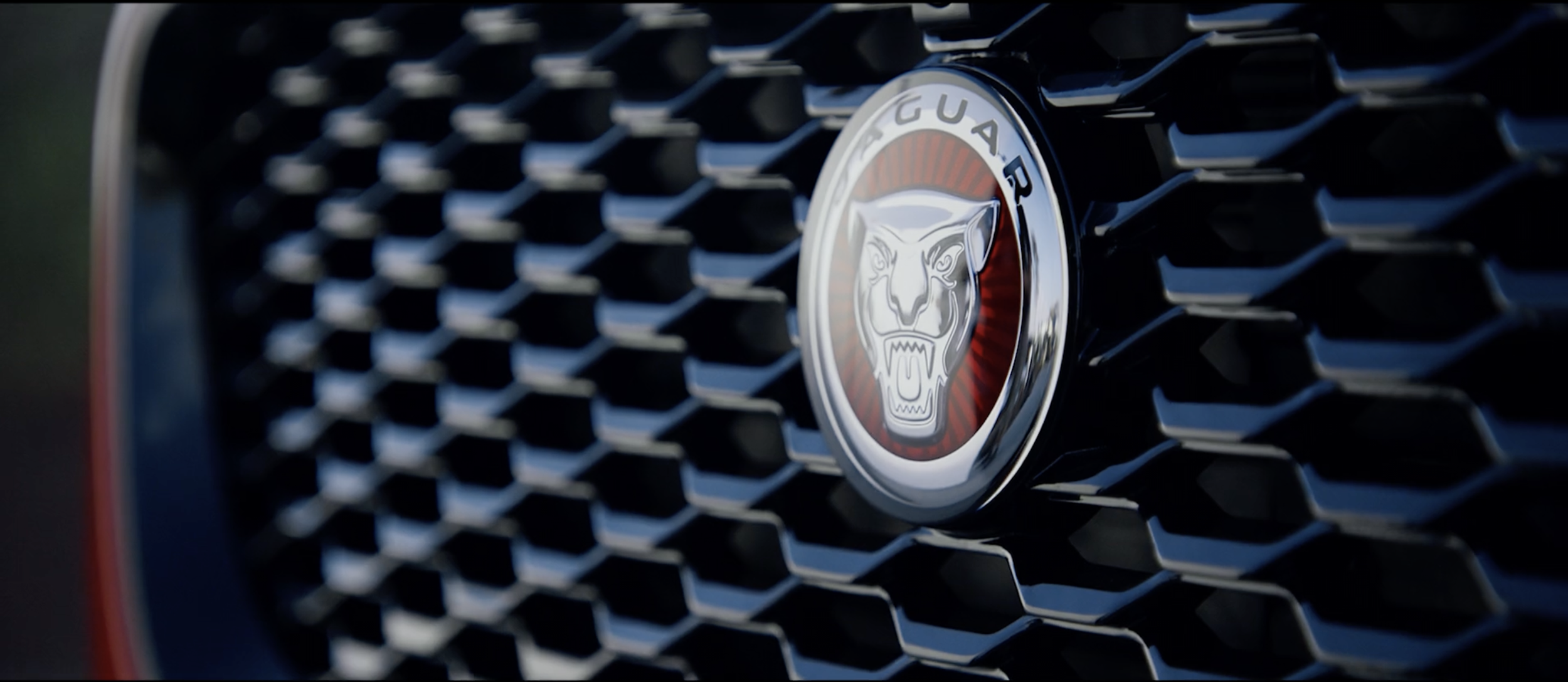 Stylish image of a red Jaguar E-PACE badge in a commercial filmed on location in Tenerife by cinematographer Callan Green ACS NZCS