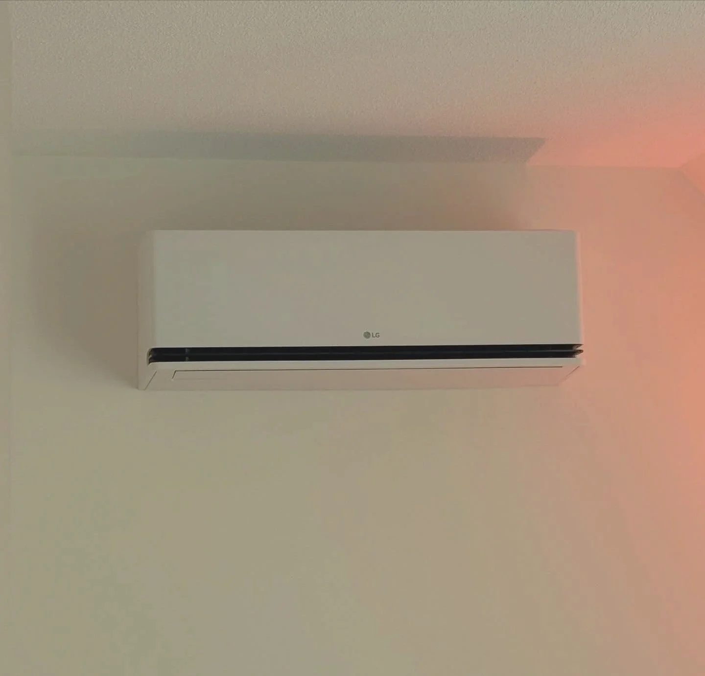 Witte airconditioner met het LG-logo, bevestigd aan de muur