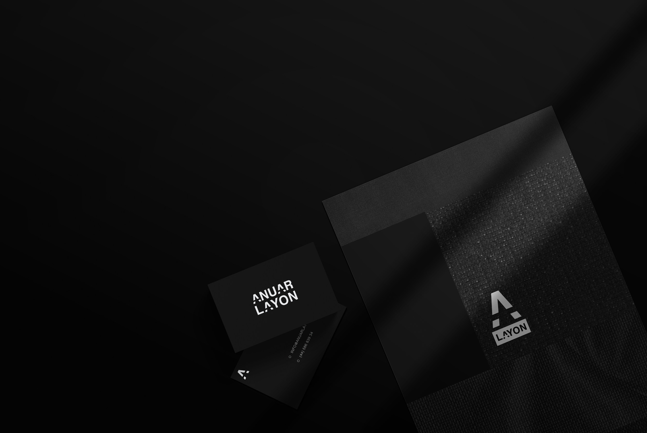 Registro en color negro con logotipos blancos y gráficos en tonos grises, con cajas y tarjetas de presentación dispuestas sobre una superficie negra y fondo negro.