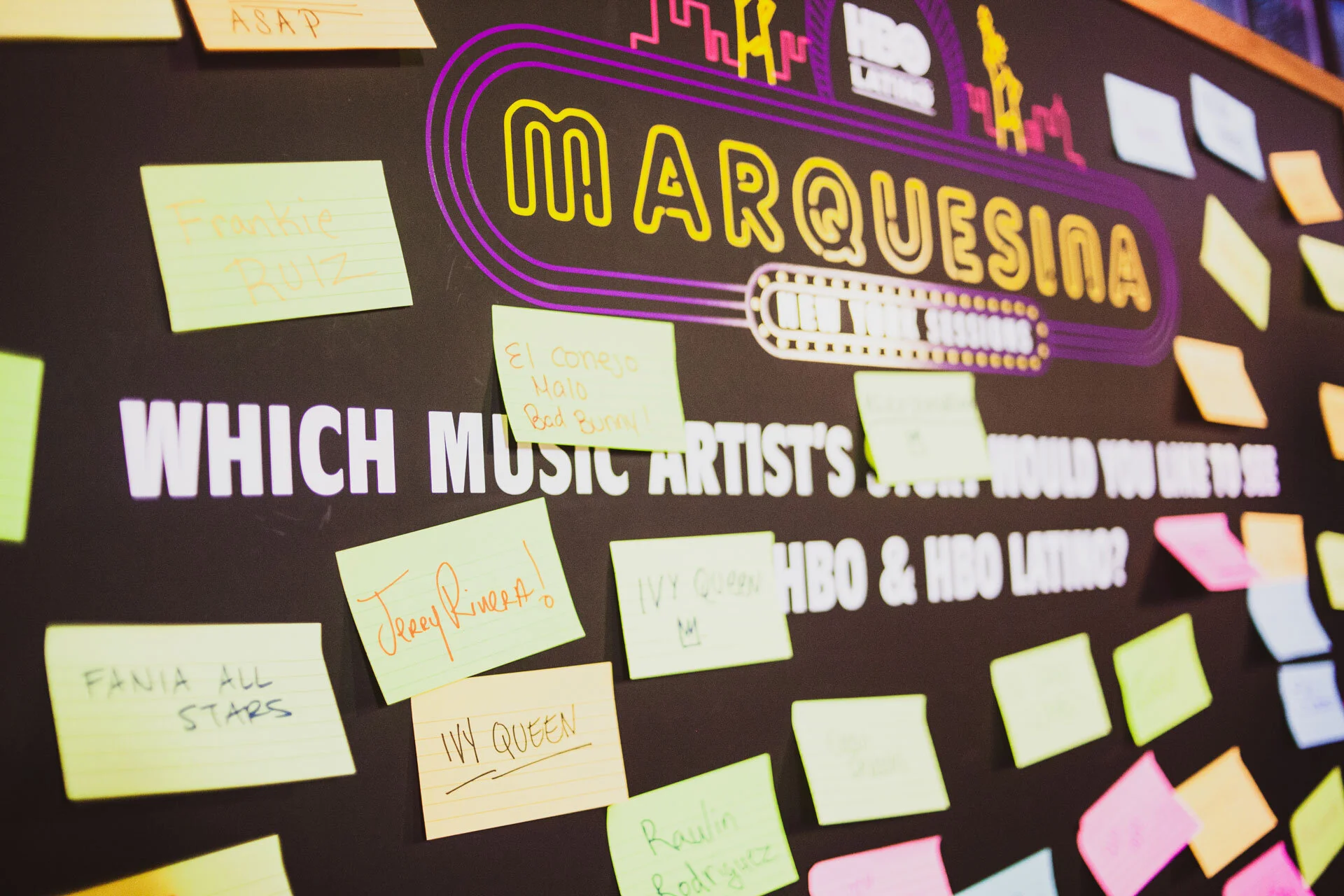 Cartel con la pregunta en inglés y muchos notas adhesivas de colores con respuestas, en fondo negro y algunos textos en inglés y en letras grandes en la parte superior. 