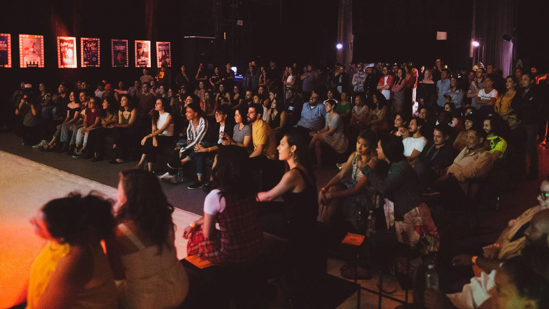 Audiencia sentada en teatro observando un espectáculo.