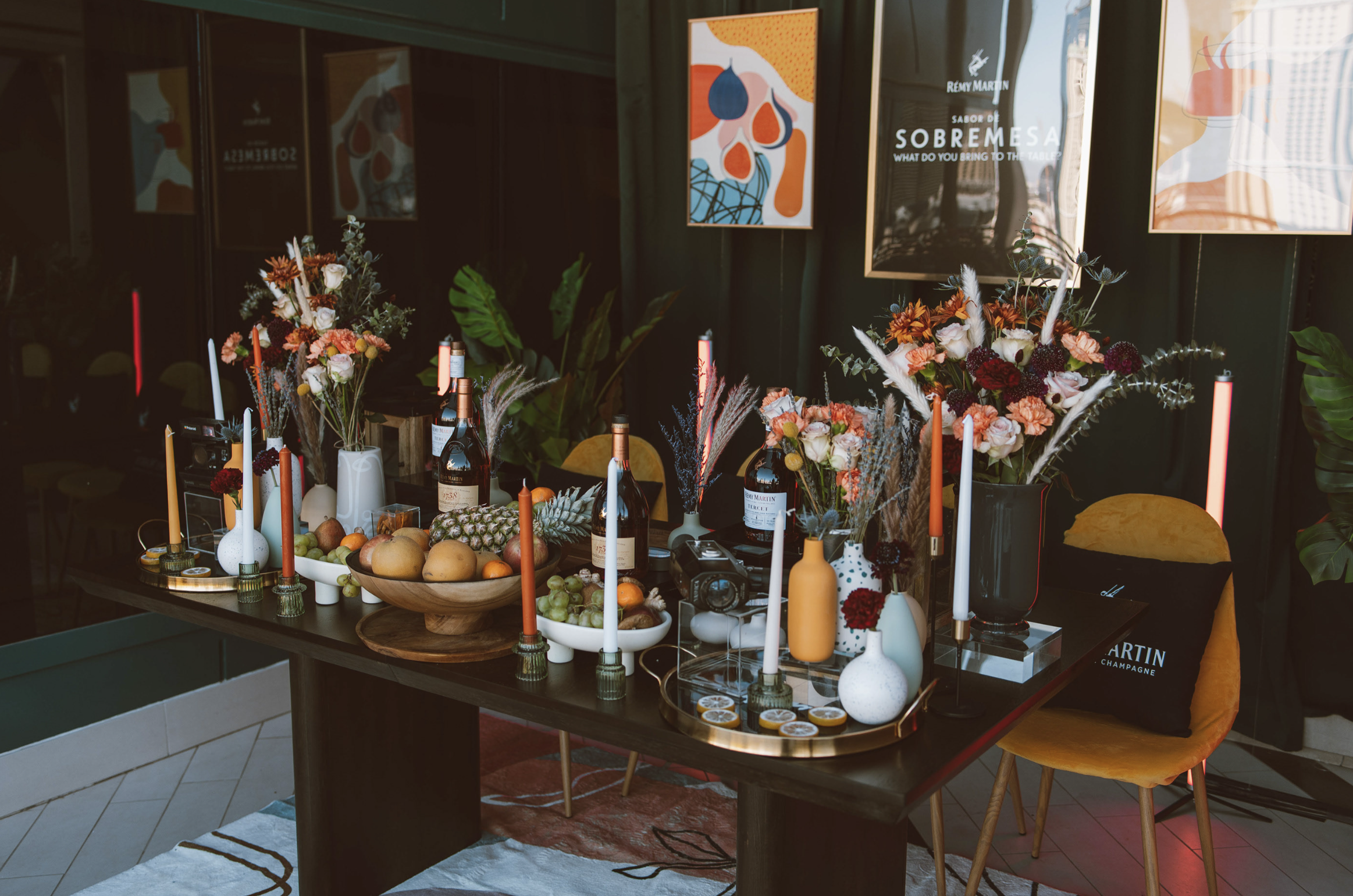 Mesa decorada con flores, frutas y velas en un ambiente elegante