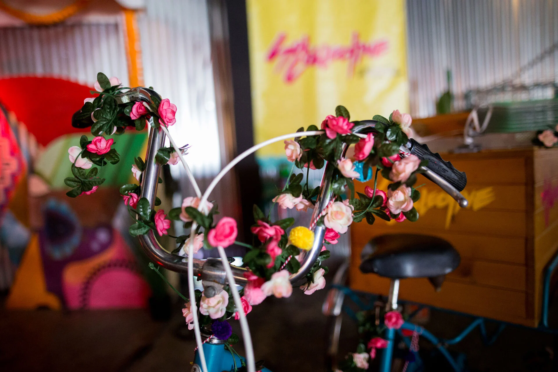 Una bicicleta decorada con flores artificiales en un entorno interior.