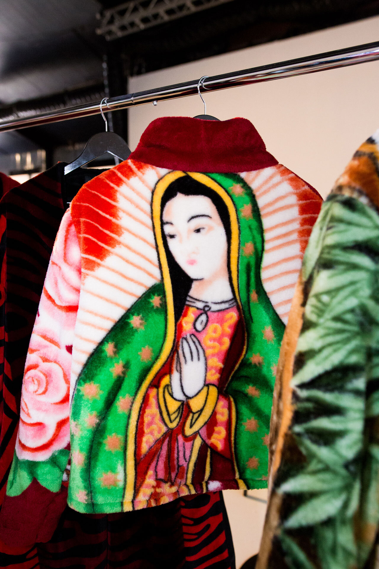 Chamarra con bordado de la Virgen de Guadalupe en la espalda, en un perchero