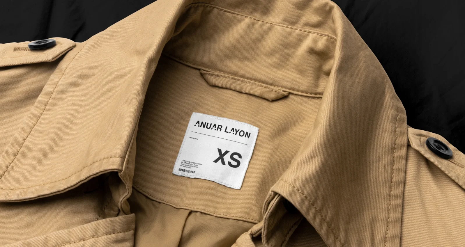 Parte de una chamarra color beige con etiqueta que dice 'Anuar Layon' y talla XS.