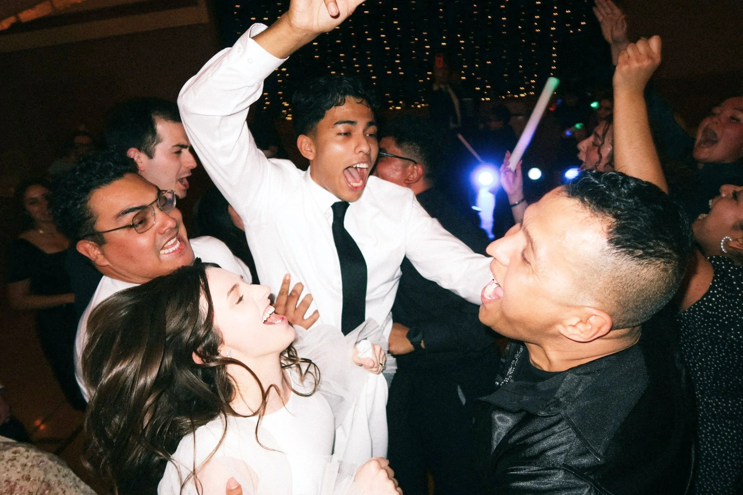 High-energy wedding reception in Philadelphia, featuring guests joyfully dancing with colorful glowsticks. Capturing the excitement of Luxe Entertainment Weddings as a top Philadelphia wedding DJ.