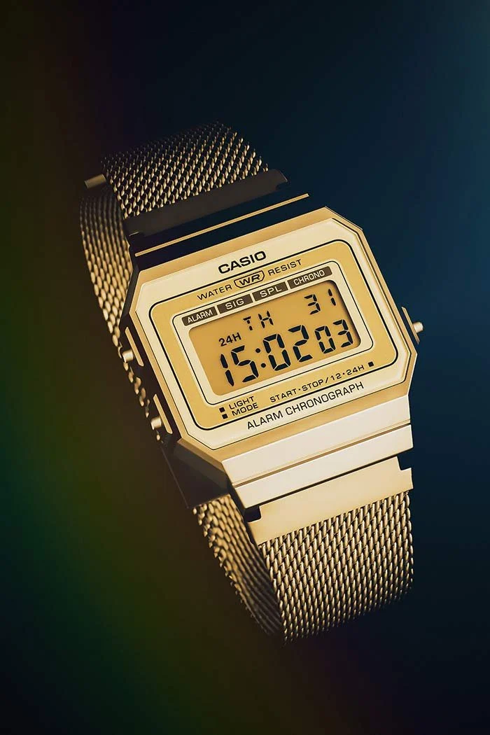 Une montre digitale Casio en acier inoxydable avec affichage numérique indiquant 15:02:03, avec un fond sombre et une lumière douce