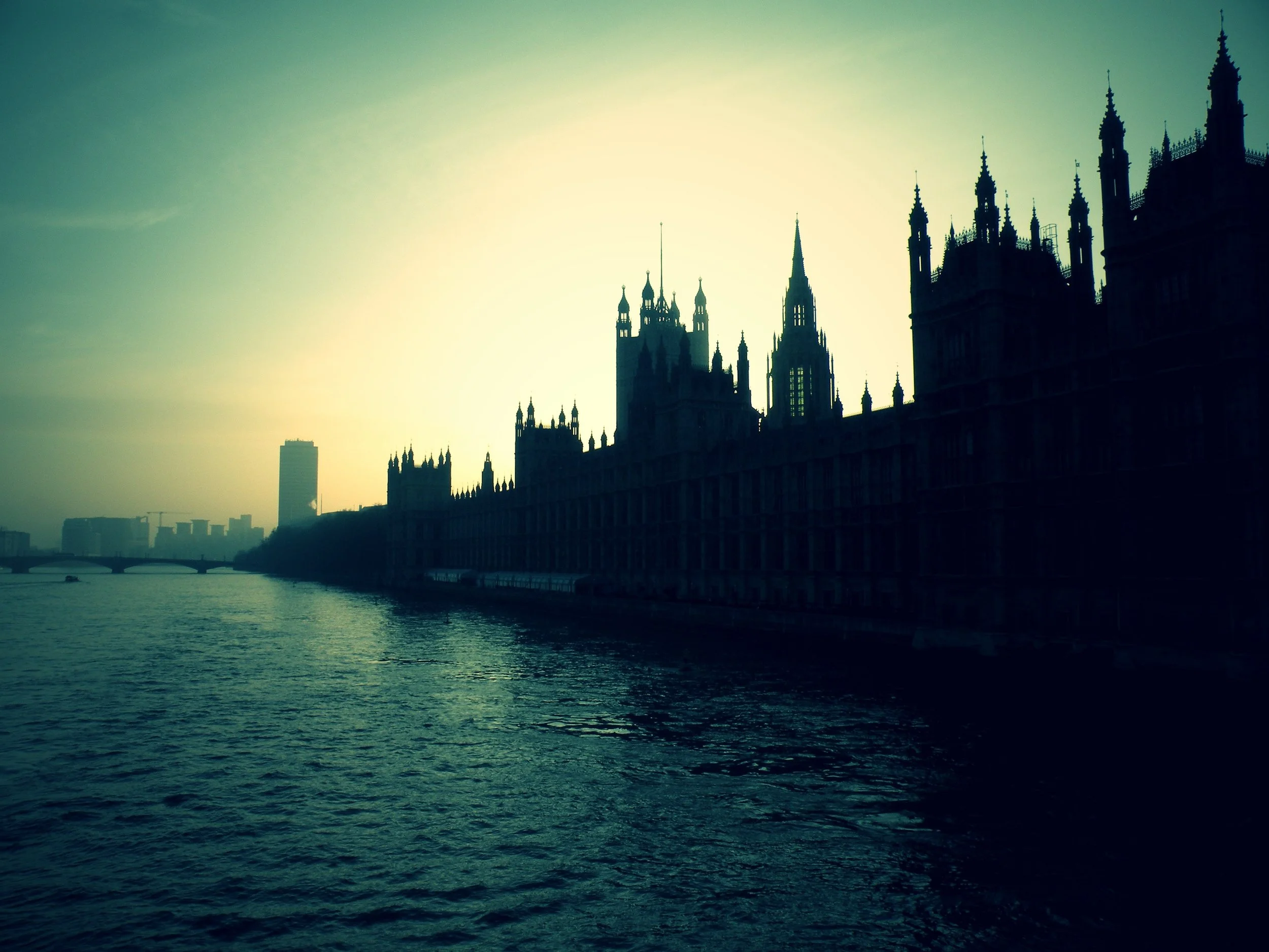 Silhouette of the Palace of Westminster by the Thames River during sunset or sunrise.