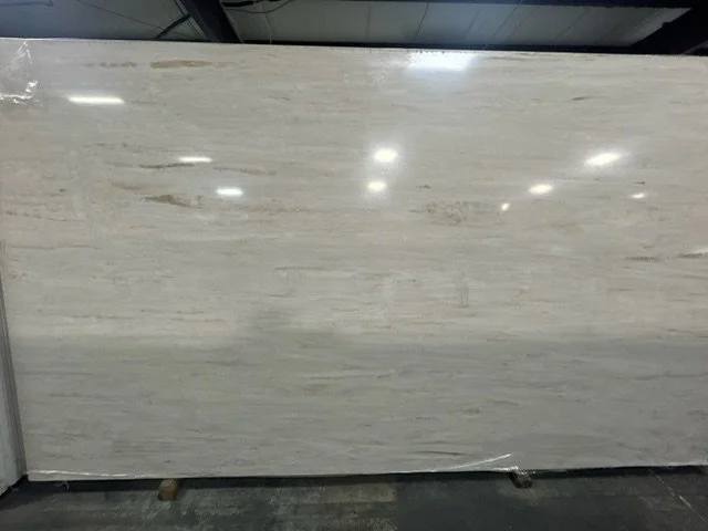 Large white marble slab with subtle gray veining on display in a store.