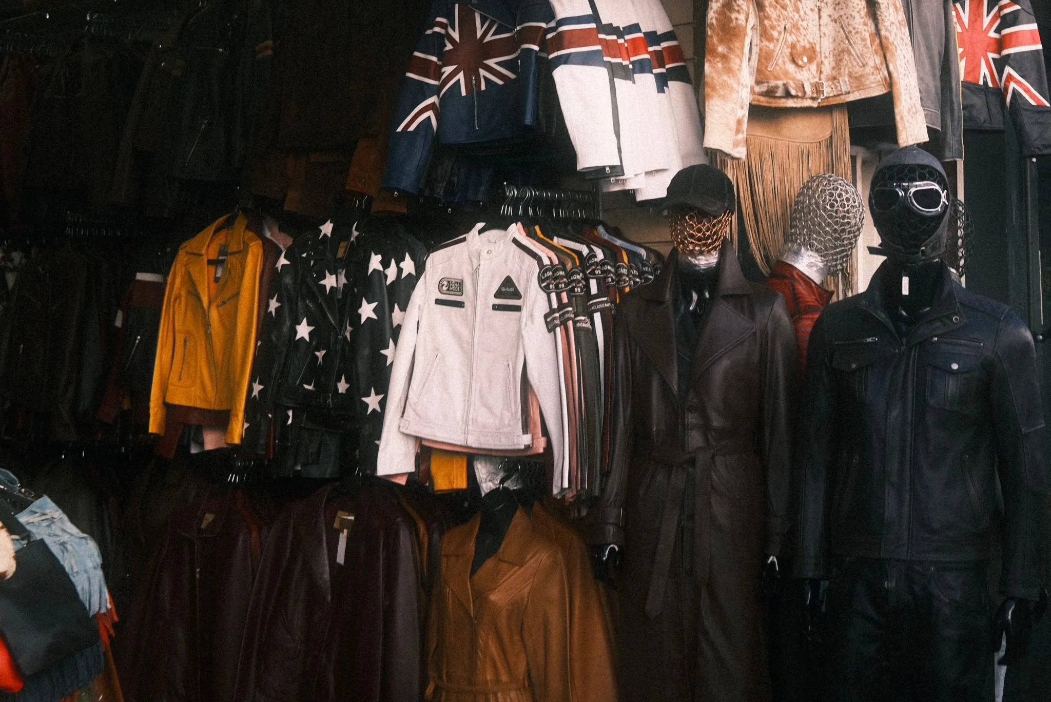 Clothing store display with jackets and mannequins wearing leather and patterned jackets, some with masks and hats, and various Union Jack designs on the apparel.