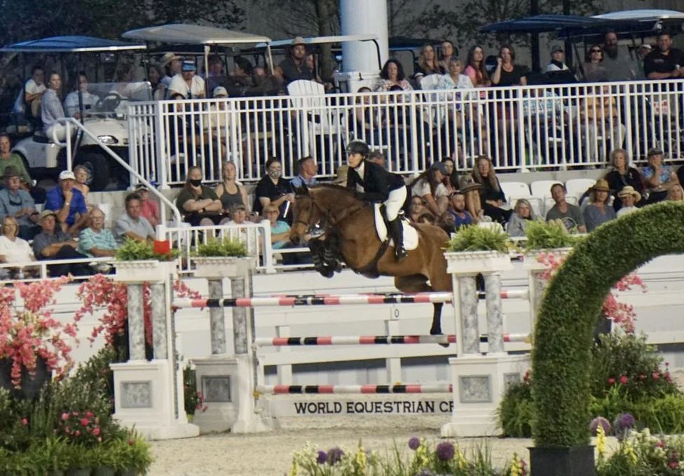 Cinven CR (Cilantro) clearing a white and red fence at World Equestrian Center.