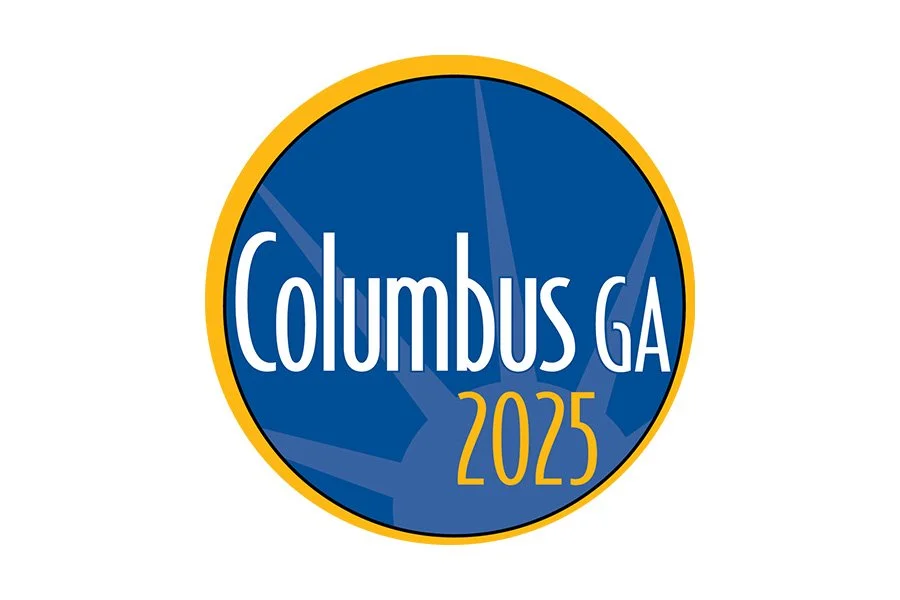A circular logo with a blue background, yellow border, the word "Columbus" and "GA" in white, and the year "2025" in yellow.