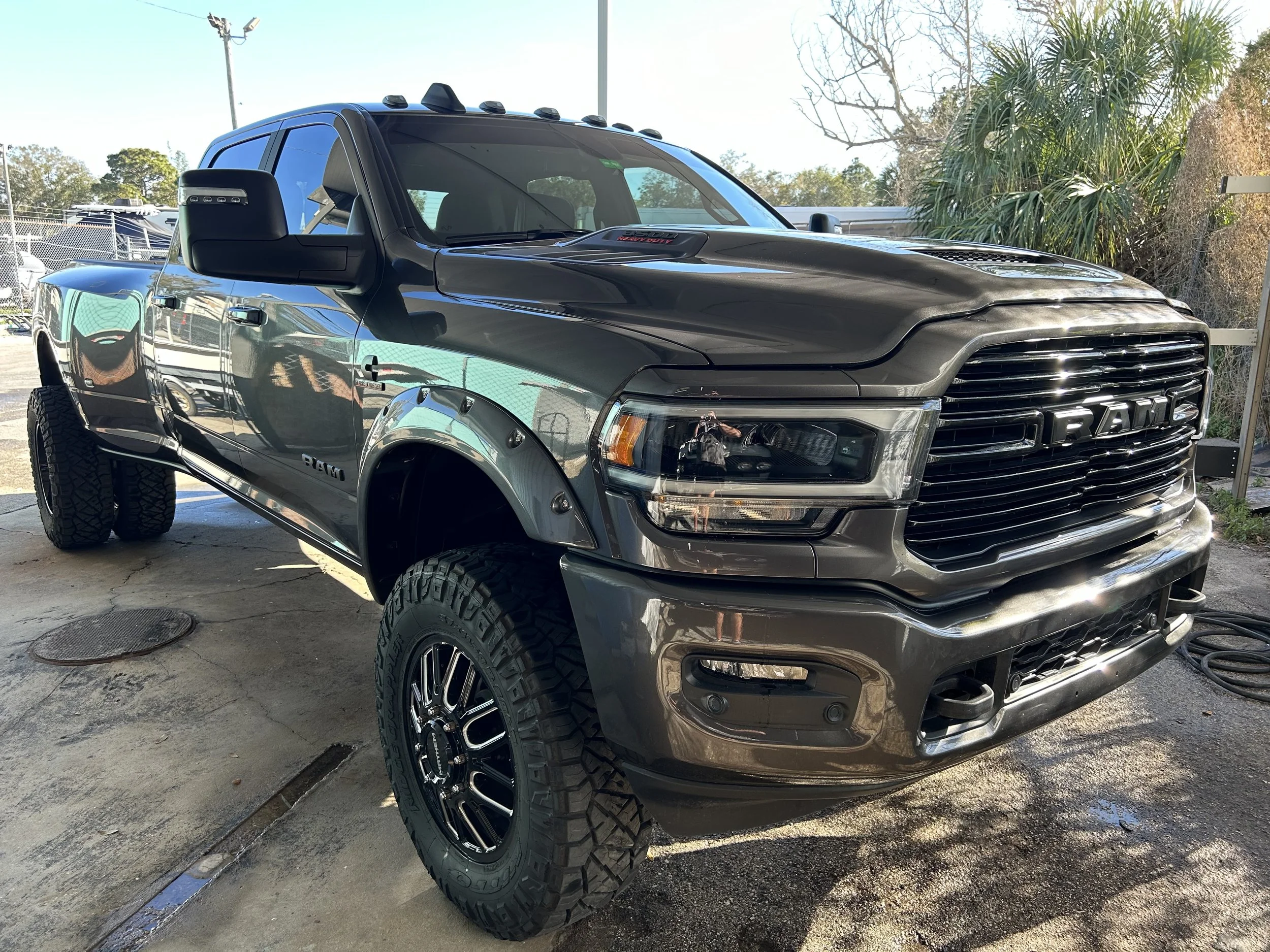 Black Ram pickup truck parked at a car wash or detailing service.