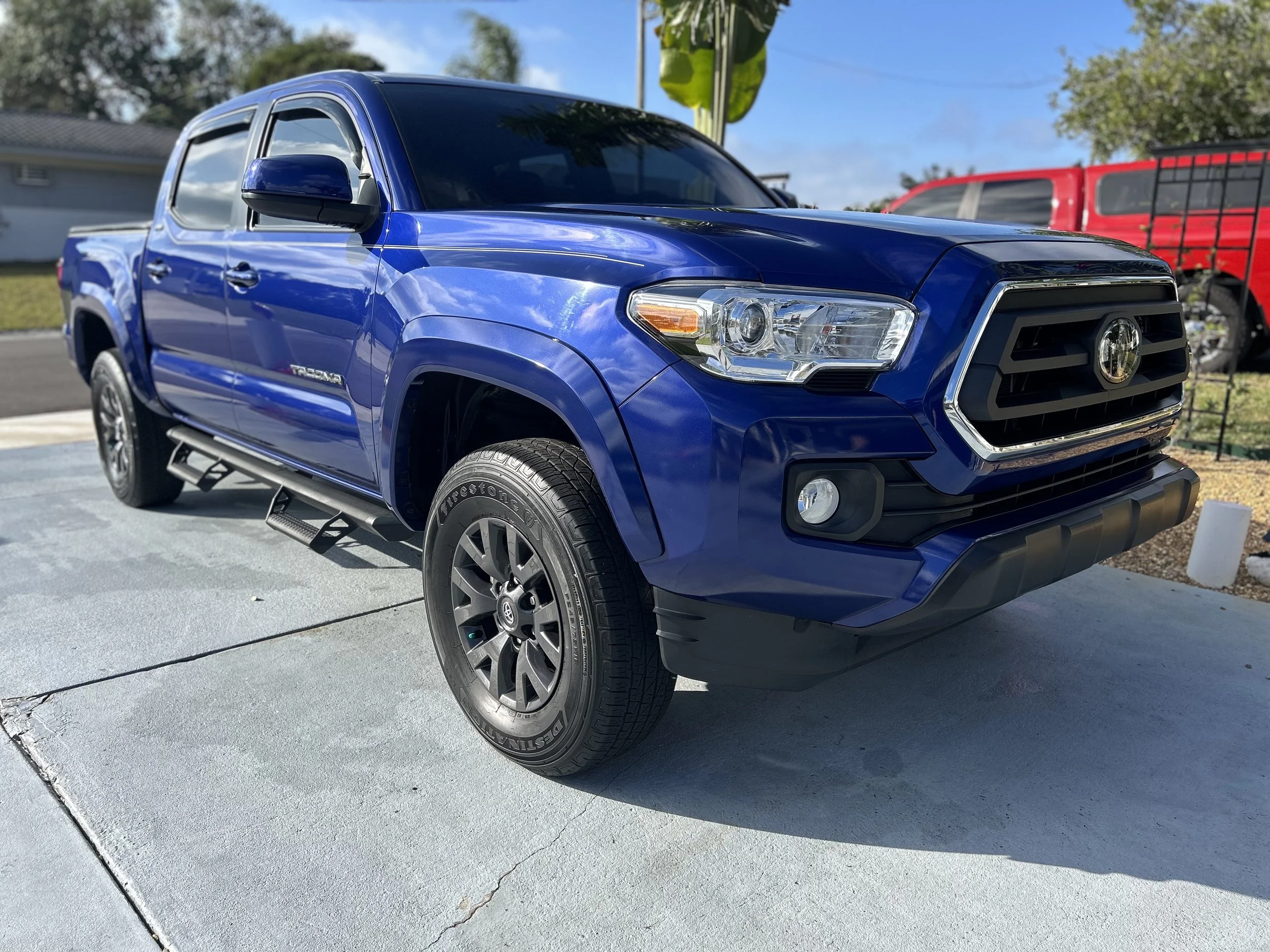 Blue Toyota Tacoma pickup truck parked on a driveway.