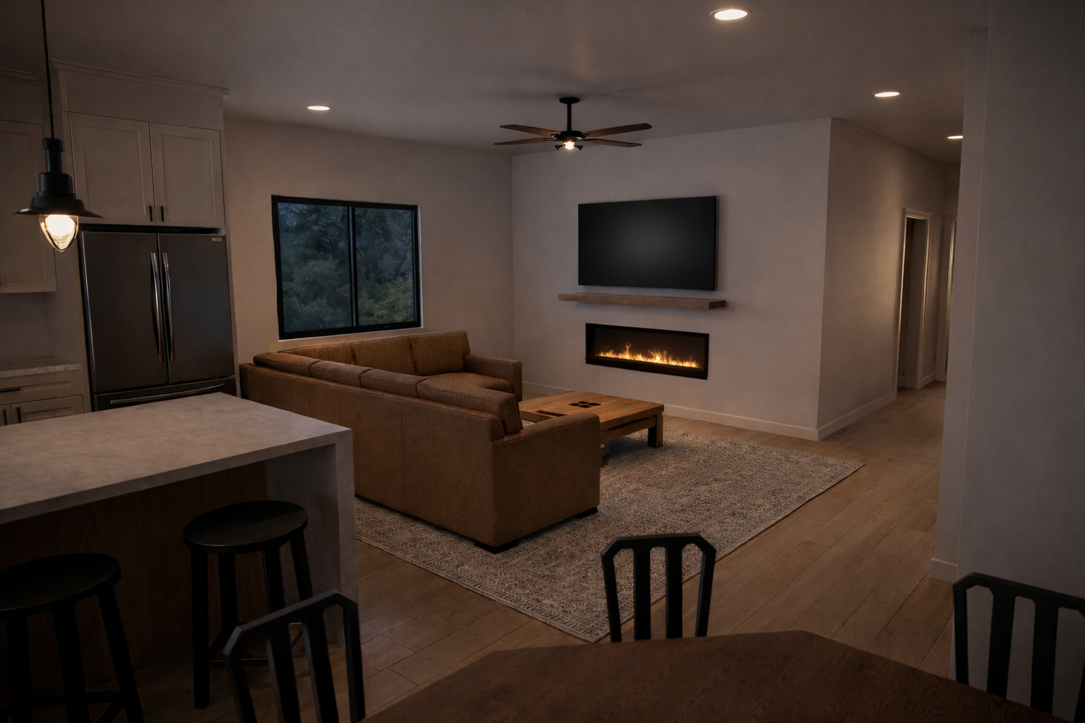 Open living room with fireplace and adjacent kitchen.
