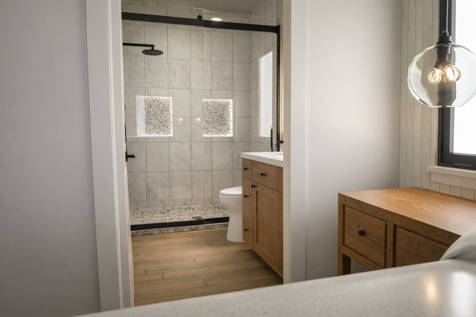 Bathroom with glass-enclosed shower, vanity, and window.