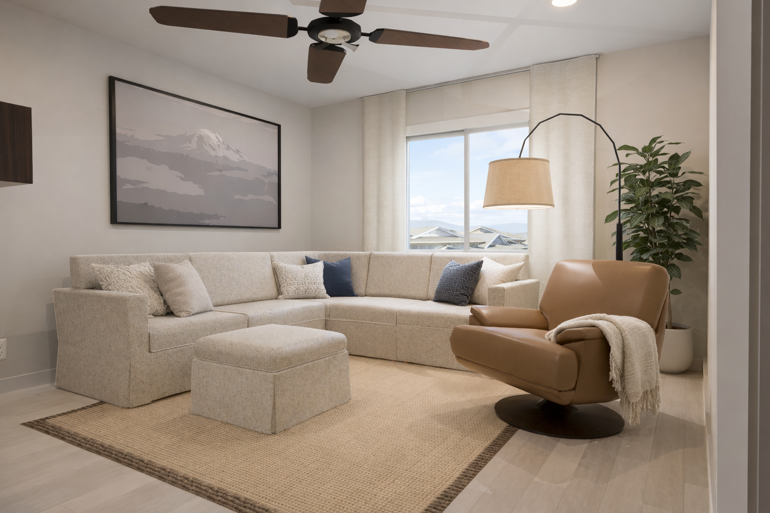 Living room with seating area, large window, and ceiling fan.