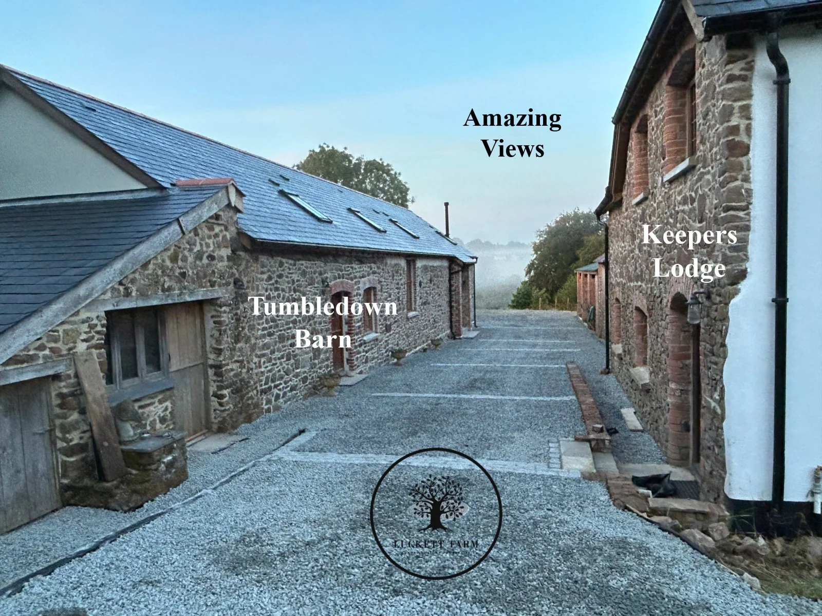 A rural scene at Lucket Farm featuring a stone barn on the left, a gravel parking area, and a stone building on the right, with trees and mist in the distance. Labels indicate 'Tumbledown Barn', 'Keepers Lodge', and 'Amazing Views'.