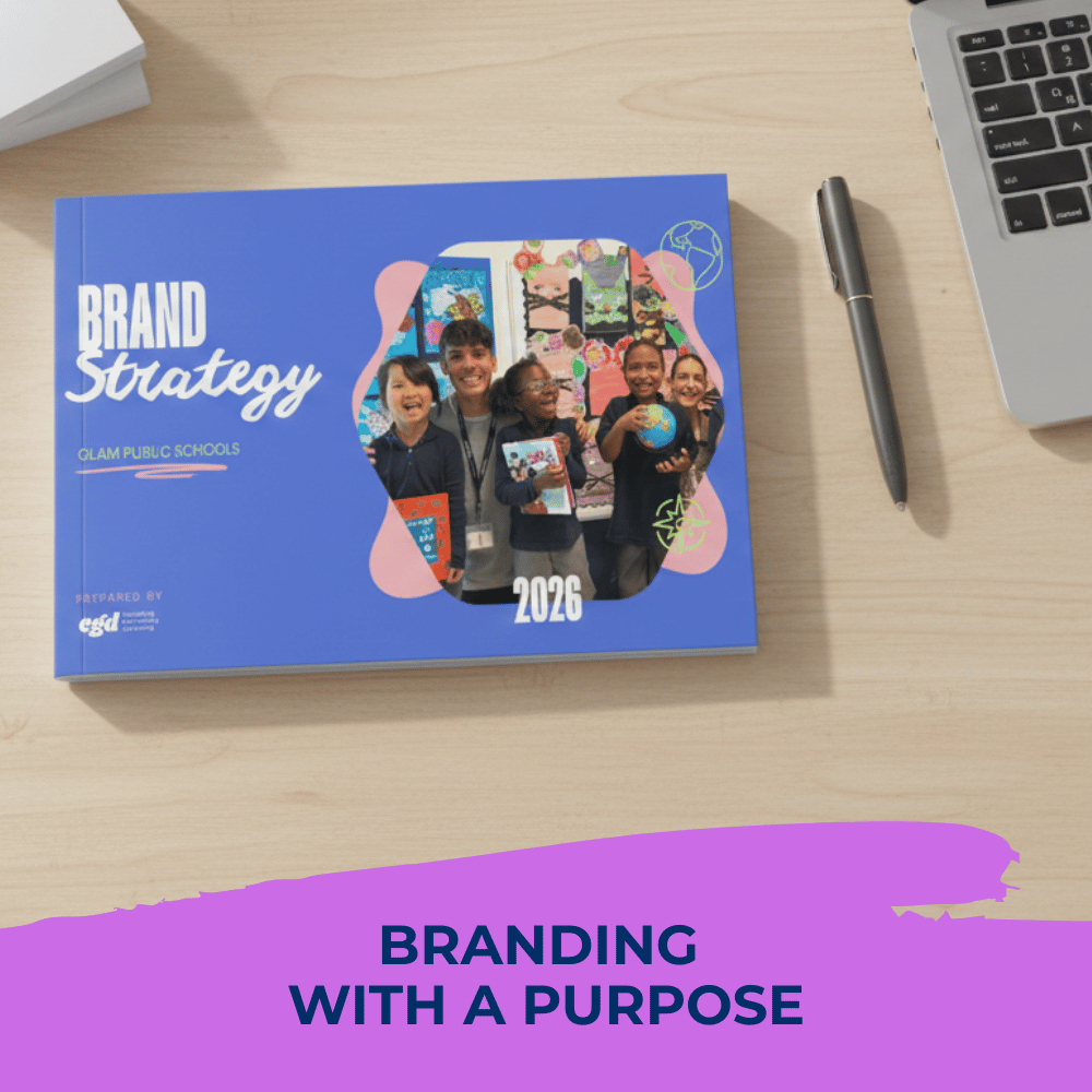 A Brand Strategy book with a photo of smiling children, placed on a light wooden desk in an office setting.
