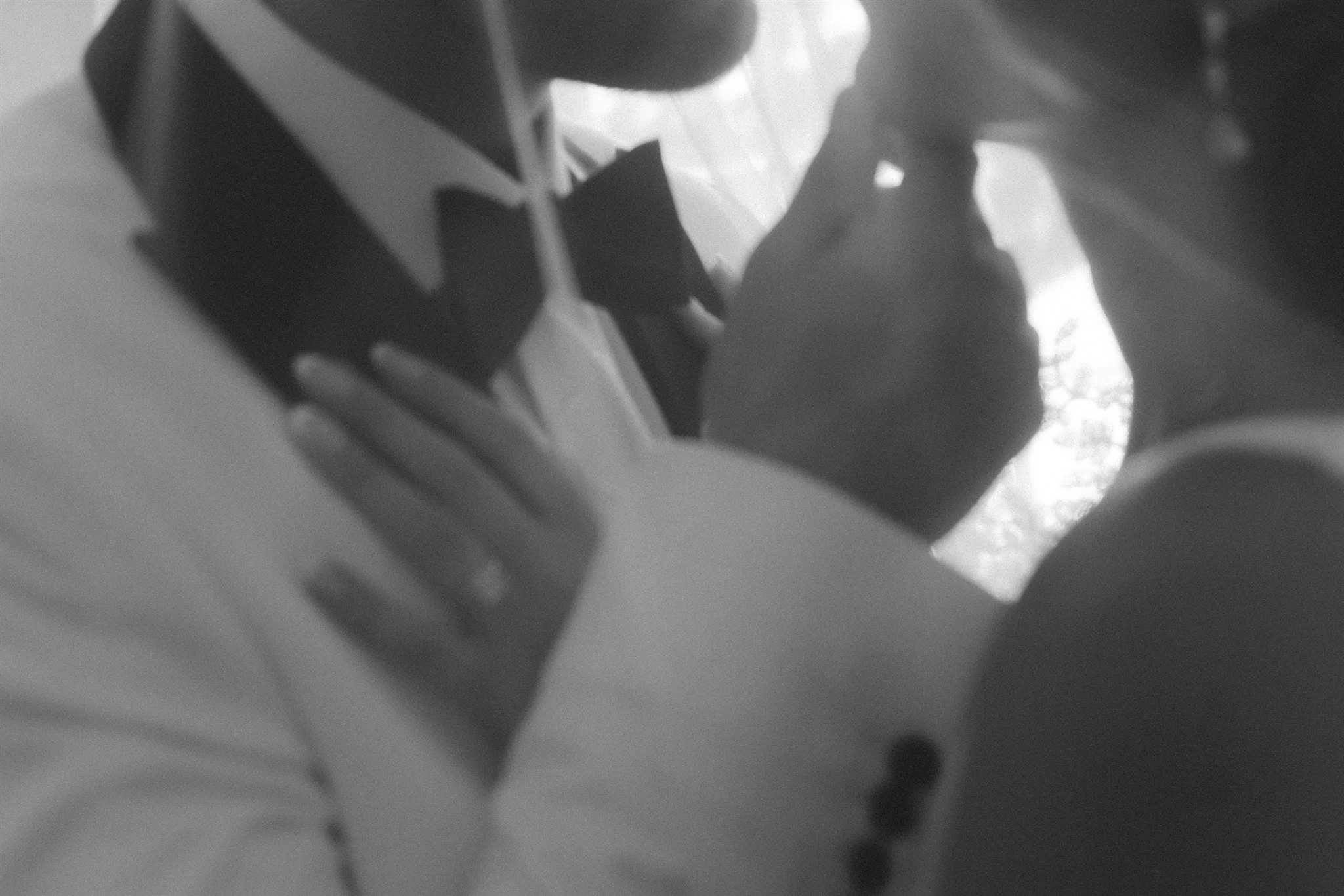 A black-and-white photo of a man and woman facing each other, apparently about to kiss, with their faces close together and eyes closed.