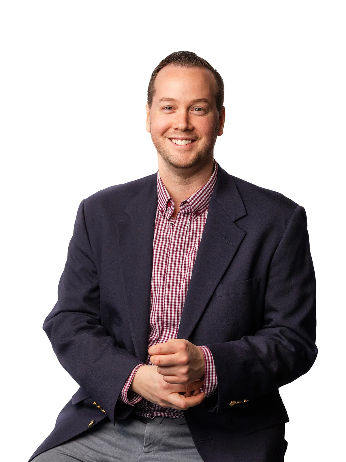 An accountant fixes his sleeve button while smiling at the camear