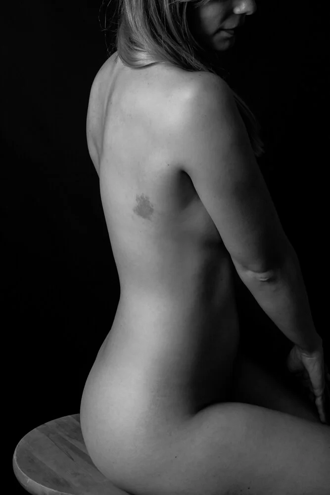 artistic black & white image of a woman's curving back
