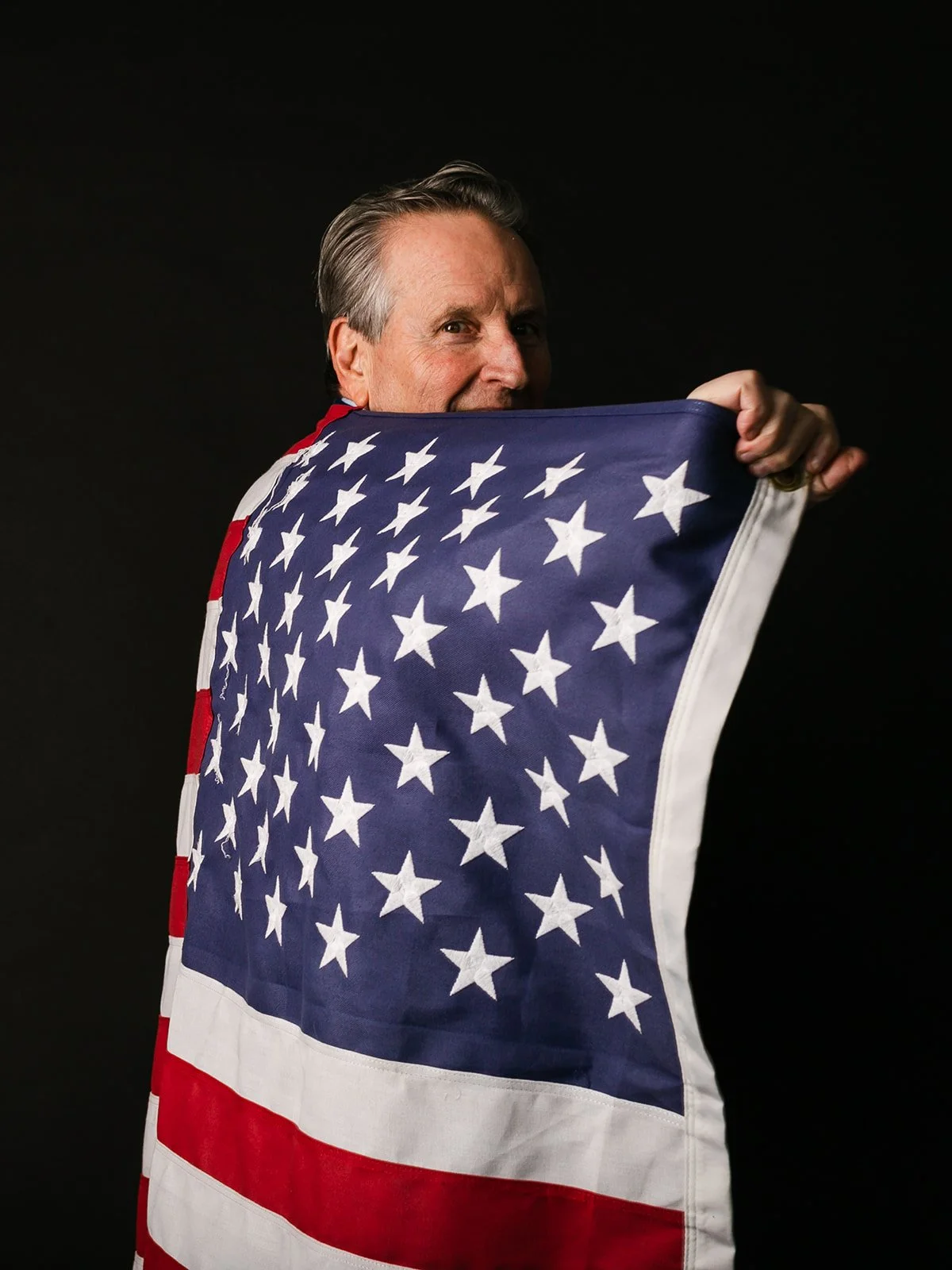 A man holds his U.S. flag from the Vietnam War like a superhero cape