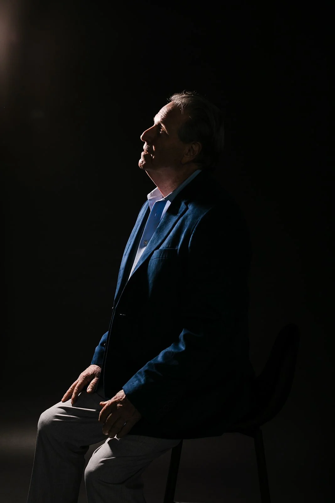 A man in a dark scene looks up the sky