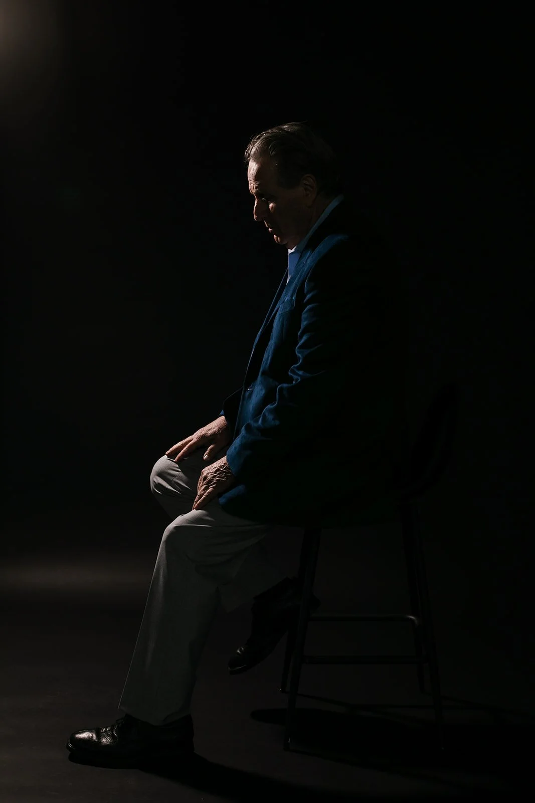 A man, looking dejected, sits and looks down
