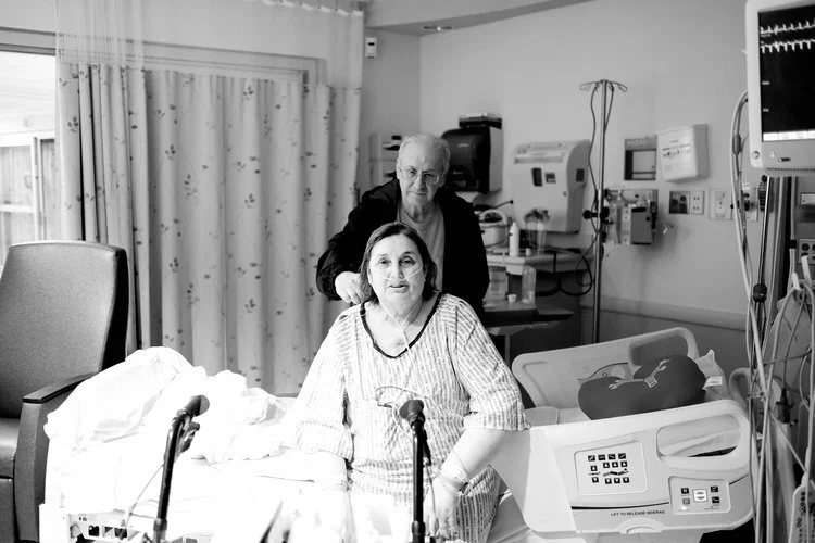 Dad brushes mom's hair after the nurses shampoo her hair following surgery