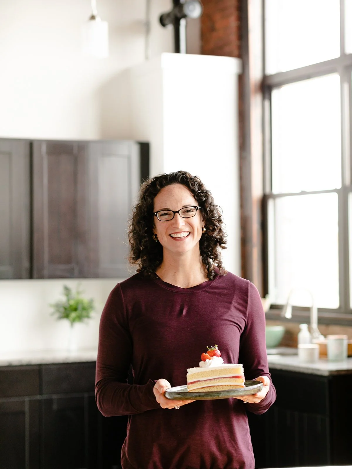 A dietician and fitness coach holds a piece of cake to demonstrate how to have a healthier relationship with food