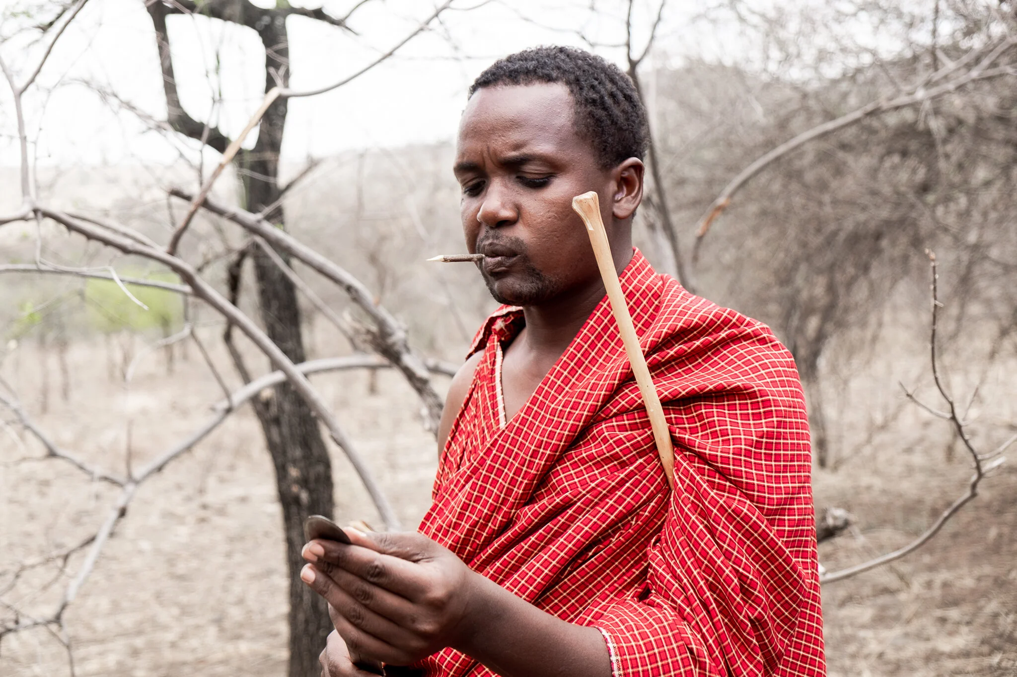 Maasai tribal member carves a notch in wood