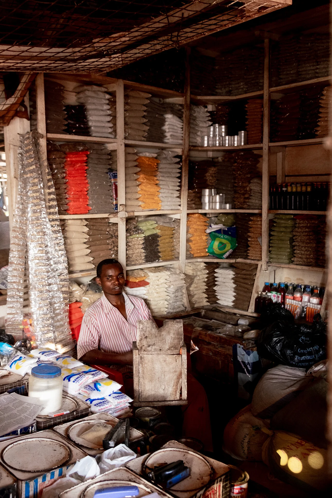 documentary photo of a local in Tanzania selling spices and seasonings at a local market