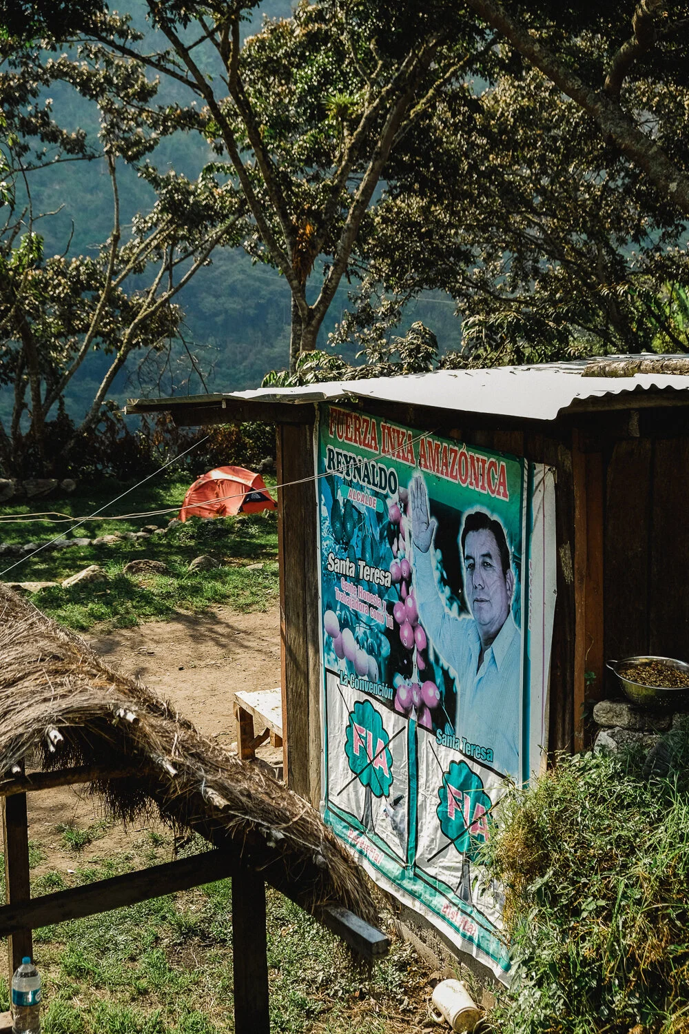 A political campaign poster outdoors showing a man in a white shirt, with text in Spanish supporting a candidate named Reynaldo for mayor, and featuring images of Santa Teresa and a tree.