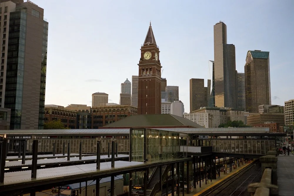 Downtown Chicago cityscape featuring the historic clock tower in Millennium Park with modern skyscrapers in the background.