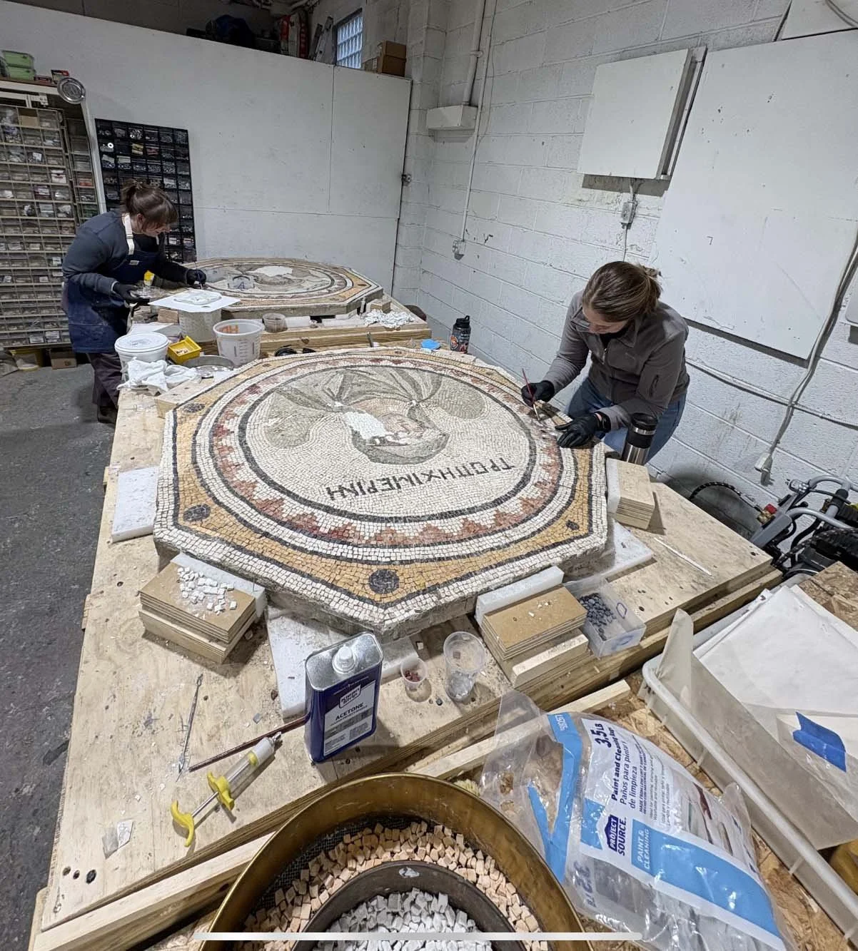 Conservators working on a mosaic sculpture