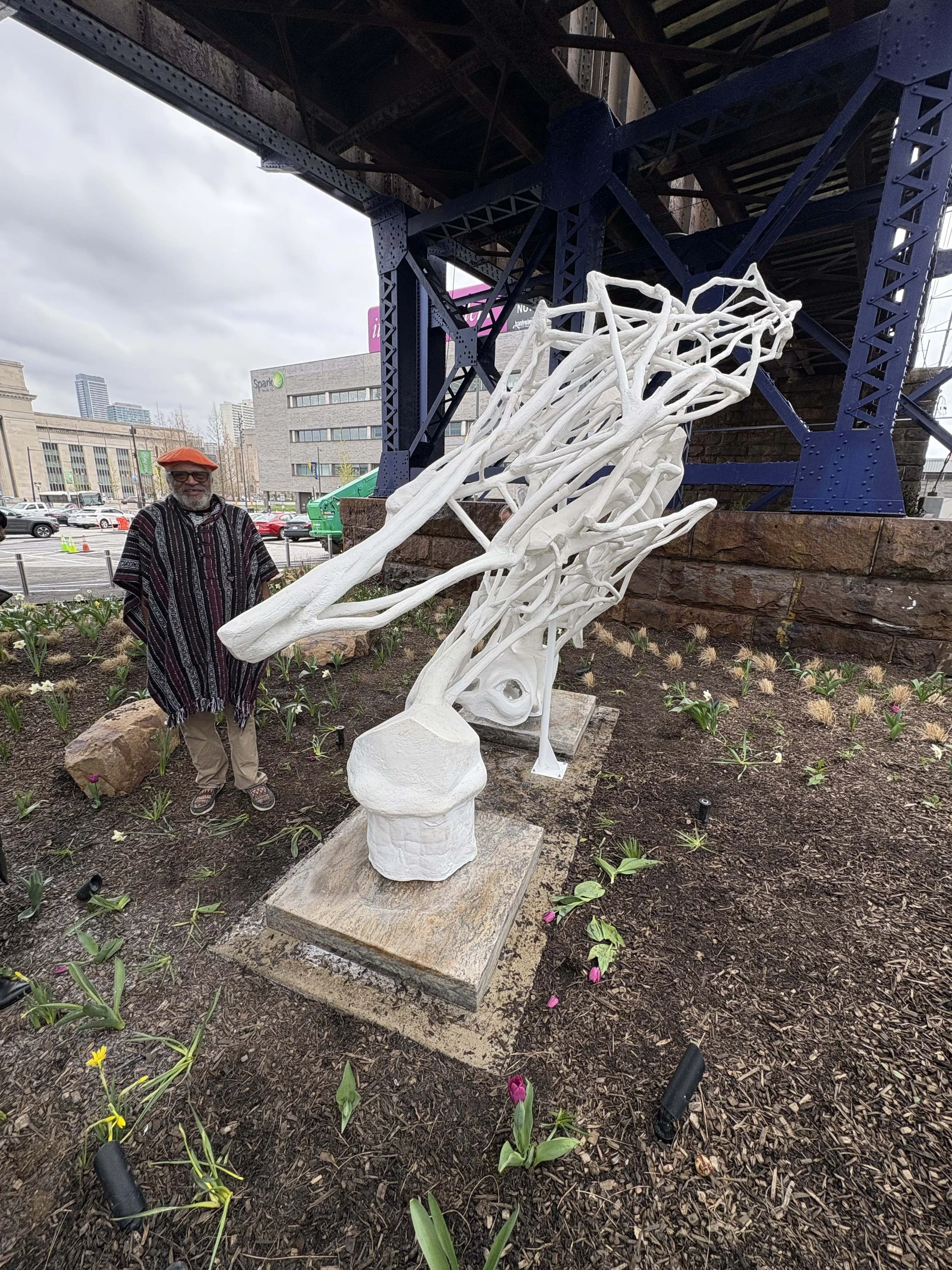 Artist standing next to sculpture