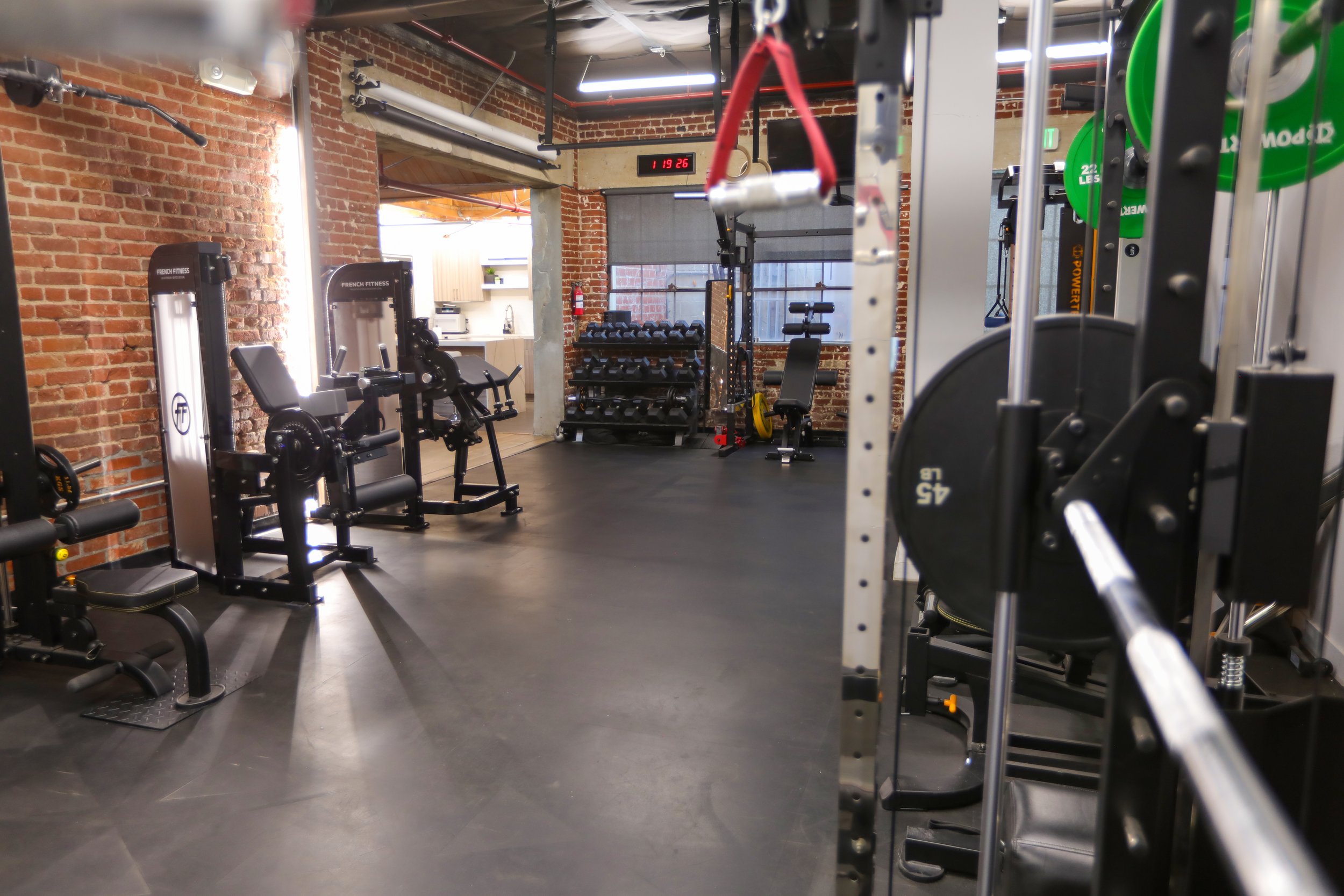 Private Los Angeles fitness studio with exposed brick walls, open training floor, and depth for camera rigs and fitness content production.