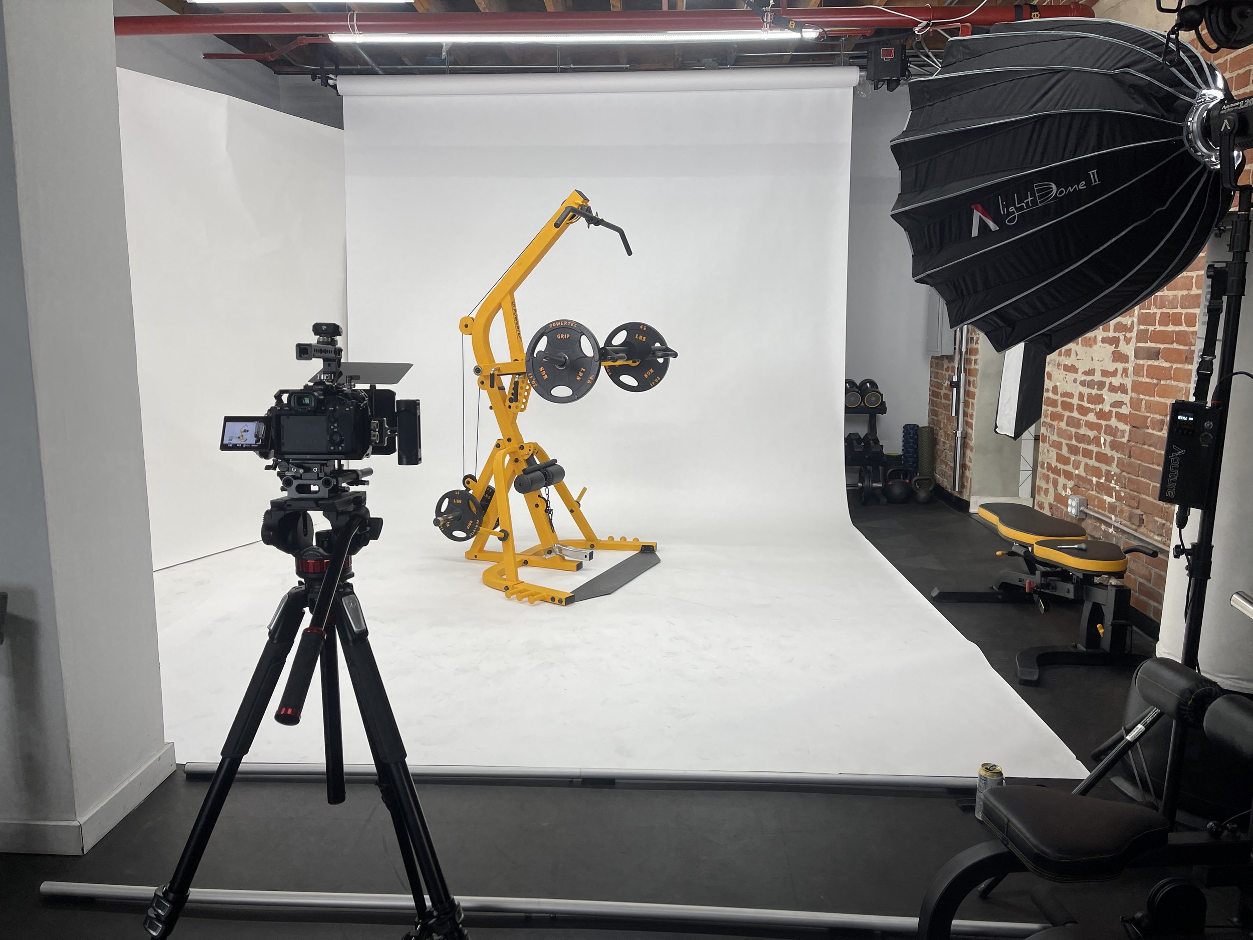 Product photography setup with Powertec strength machine on seamless white backdrop in a private Los Angeles fitness and content creation studio.