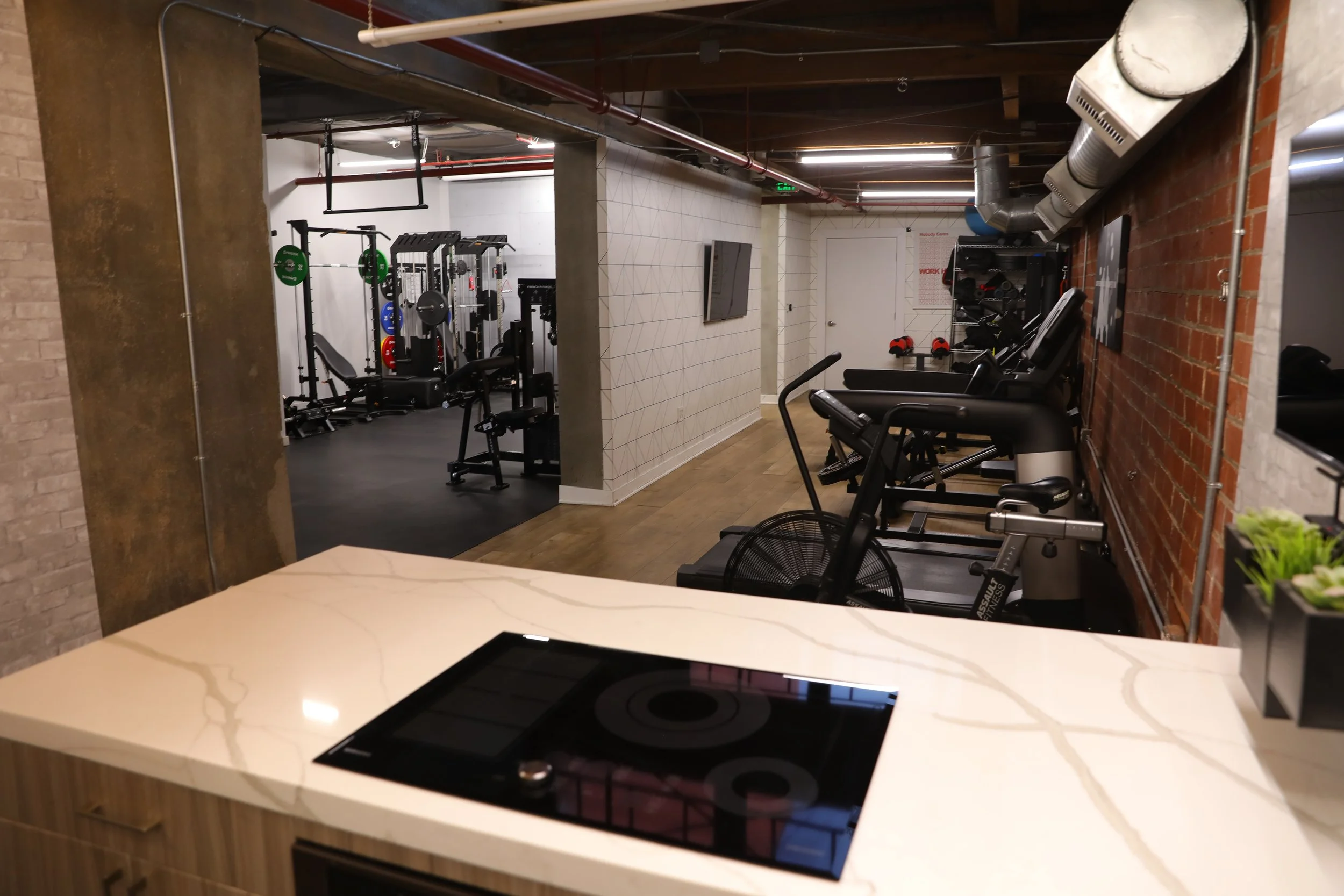 Kitchen island filming set with view into private Los Angeles fitness studio training area, designed for lifestyle content, nutrition videos, and personal training.