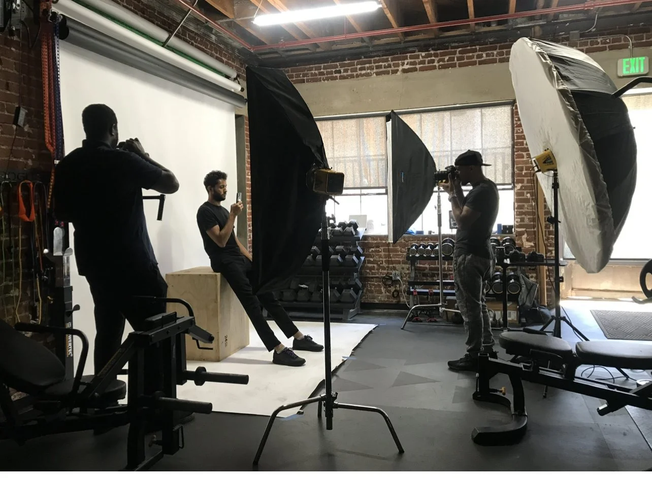Behind-the-scenes fitness photoshoot in a private Los Angeles studio with professional lighting, crew, and gym equipment for commercial photography and video production.