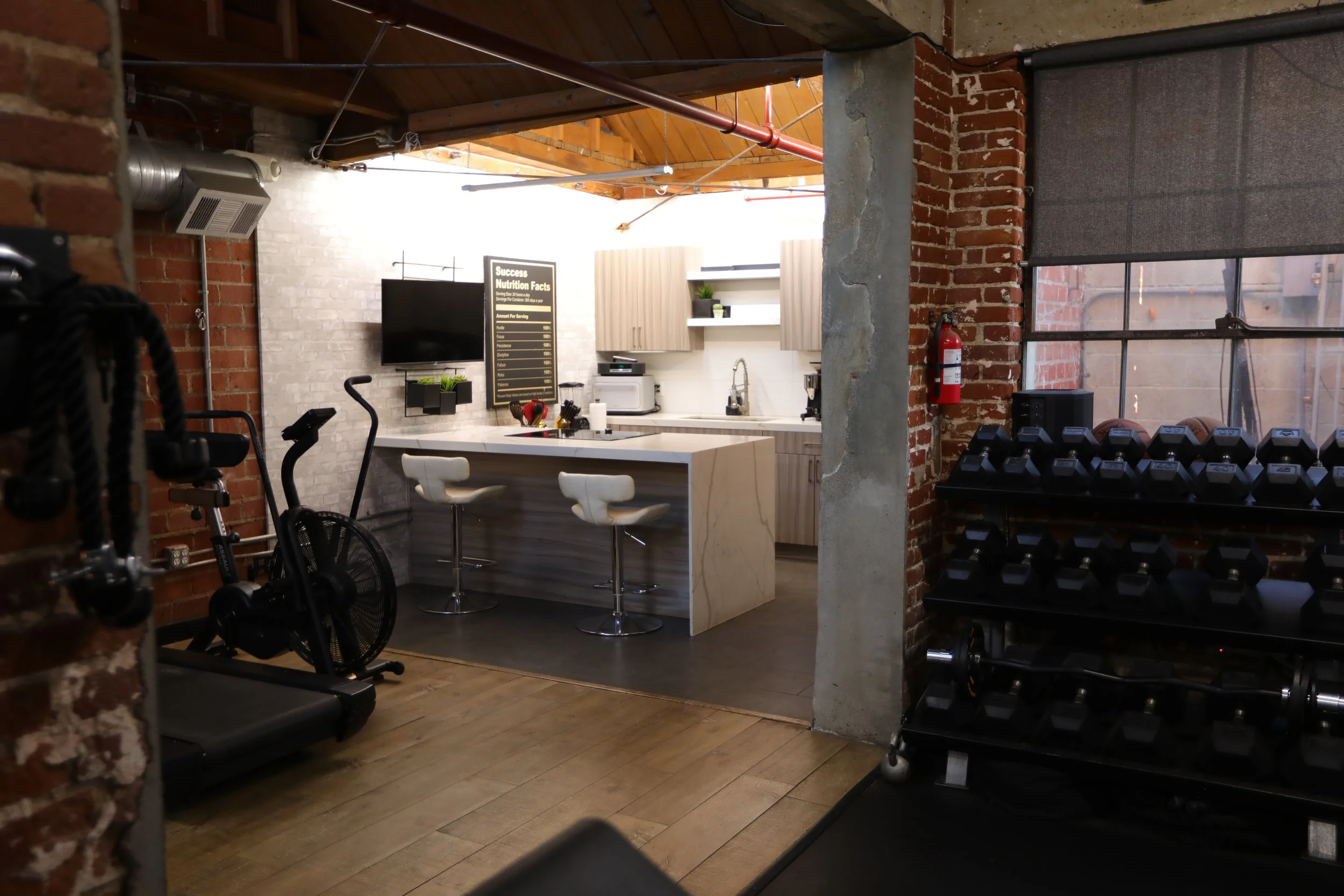 View from private Los Angeles fitness studio into modern kitchen set, showcasing combined training and lifestyle content creation space in a boutique gym studio.